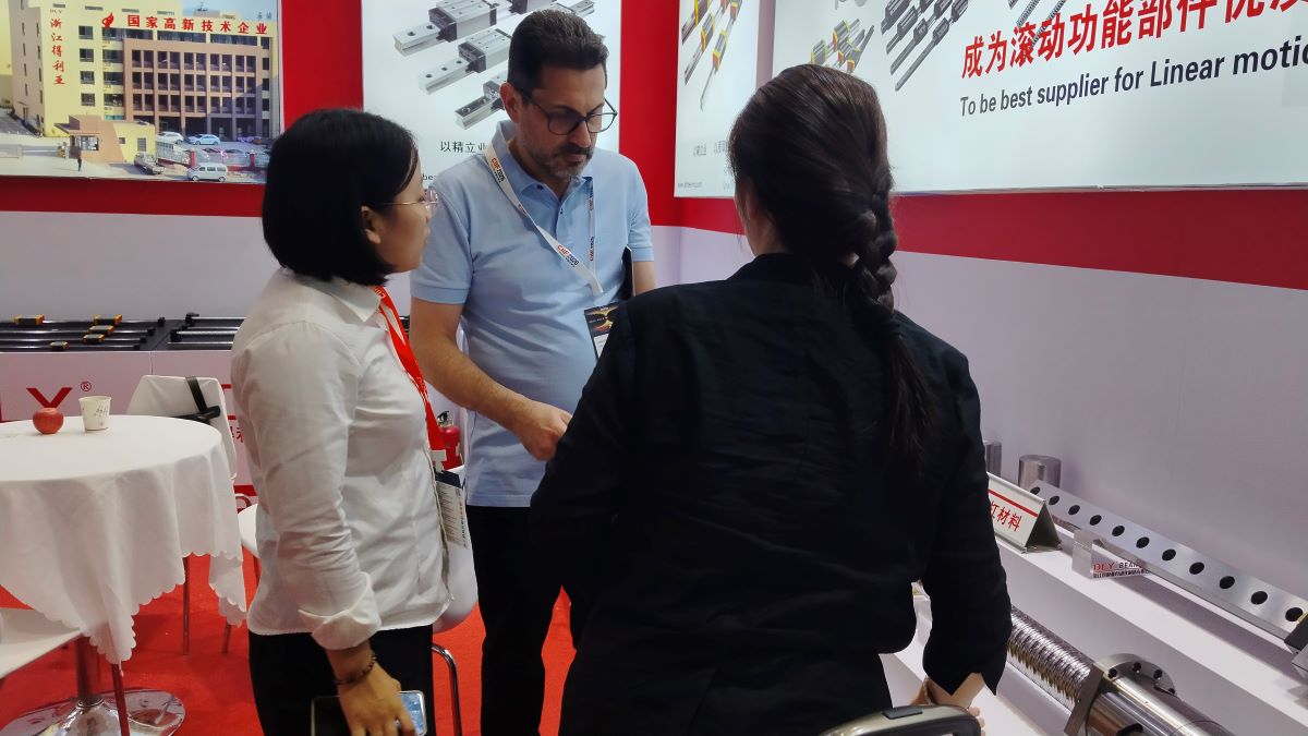 Buyers examining DLY ball screw products during a booth meeting at CIIF 2026 Buyers examining DLY ball screw products during a booth meeting at CIIF 2026